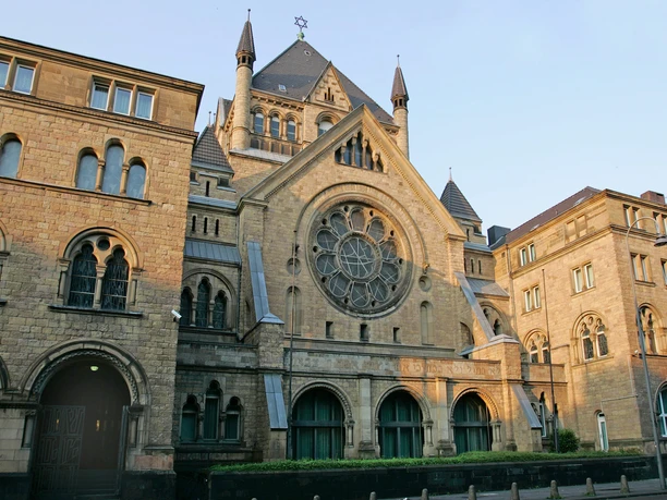 Synagogue Romanesque façade of the synagogue made of sandstone with large, round windows and pointed towers.