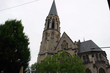 Eine neugotische Heilig-Kreuz-Kirche mit hohem Turm und Spitzfenstern.