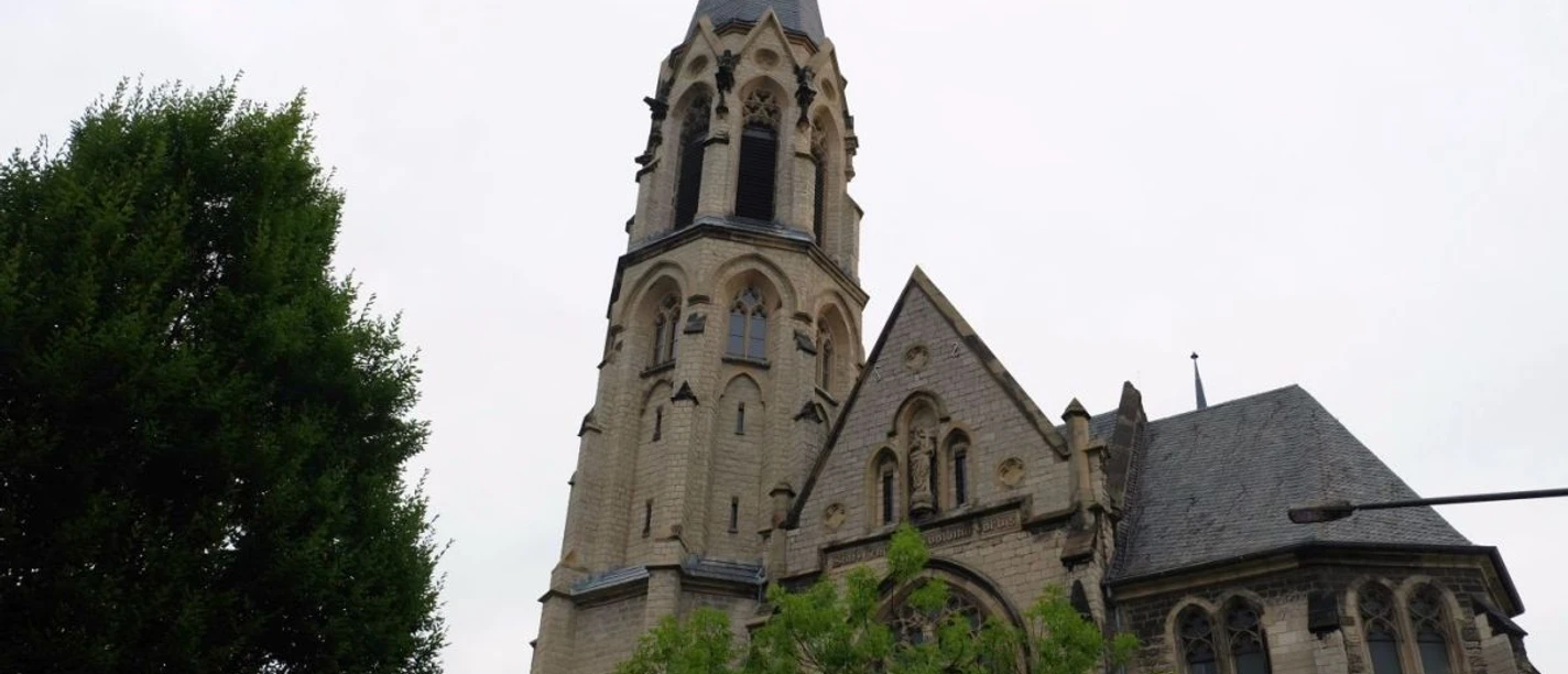 Heilig-Kreuz-Kirche Eine neugotische Heilig-Kreuz-Kirche mit hohem Turm und Spitzfenstern.
