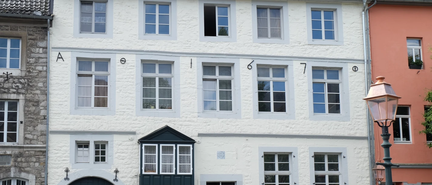 Nikolaushospital Historisches Gebäude aus dem 17. Jahrhundert mit hellen Putzfassaden, symmetrisch angeordneten Fenstern und einem Erker.