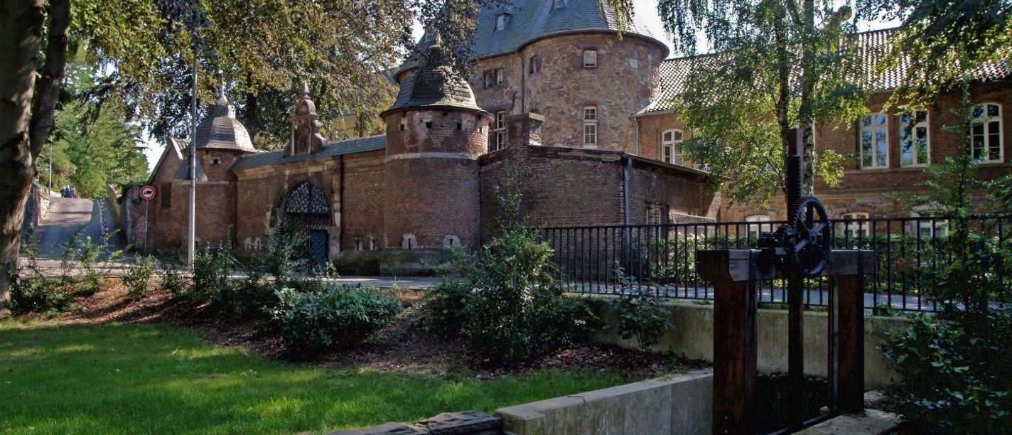 Abteigarten Kornelimünster Historische Backsteinmauer mit Türmen und gepflegter Garten.
