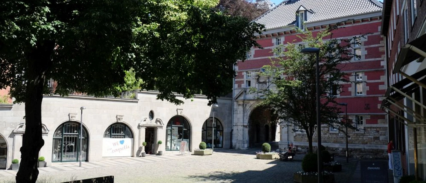 Burtscheid Marktplatz mit rotem Abteitor von der Sonne angestrahlt.