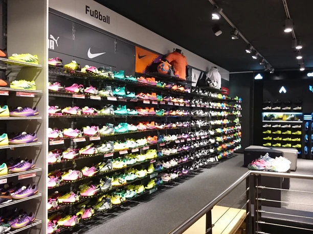 Innenraum mit Wanderegal voller verschieden farbiger Sportschuhe.