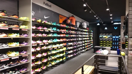 Intersport Drucks Innenraum mit Wanderegal voller verschieden farbiger Sportschuhe.
