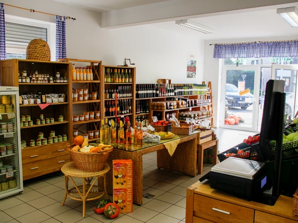 Burendeele Schulte und Specken Innenraum eines Hofladens mit Regalen voller regionaler Produkte, frischem Gemüse und Getränken.