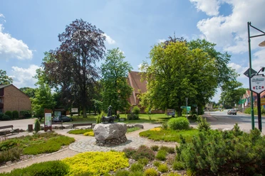 bispingen-ortsmitte De plaatselijke beschrijving van de foto van het centrum van Bispingen zou er als volgt uit kunnen zien: Een pittoresk plein in het centrum van Bispingen met goed onderhouden groene zones, bankjes en een grote boom. Op de voorgrond staat een stenen beeldhouwwerk, terwijl kleurrijke gebouwen op de achtergrond de charme van het dorp onderstrepen.