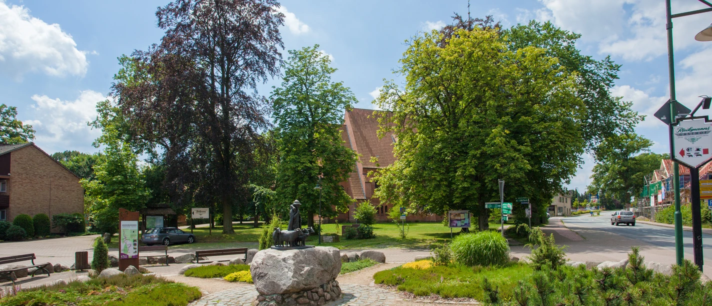 bispingen-ortsmitte De plaatselijke beschrijving van de foto van het centrum van Bispingen zou er als volgt uit kunnen zien: Een pittoresk plein in het centrum van Bispingen met goed onderhouden groene zones, bankjes en een grote boom. Op de voorgrond staat een stenen beeldhouwwerk, terwijl kleurrijke gebouwen op de achtergrond de charme van het dorp onderstrepen.