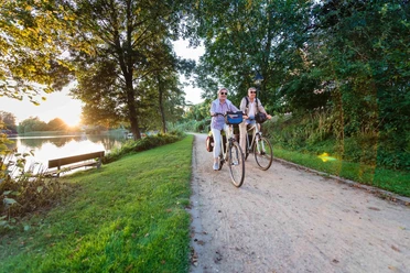 Fahrrad fahren Ein Paar fährt mit ihren Fahrrädern entlang eines Sees.