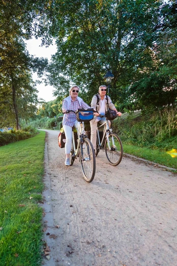 Fahrrad fahren Ein Paar fährt mit ihren Fahrrädern entlang eines Sees.