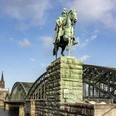 Equestrian statue of Kaiser Wilhelm I. Ein majestätisches Reiterstandbild von Kaiser Wilhelm I., im Hintergrund der Kölner Dom und die Hohenzollernbrücke.A majestic equestrian statue of Kaiser Wilhelm I, with Cologne Cathedral and the Hohenzollern Bridge in the background.
