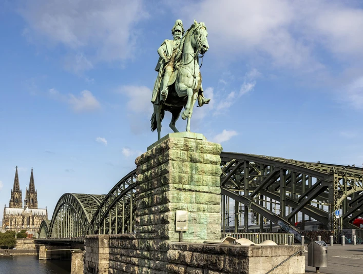 Reiterstandbild Kaiser Wilhelm I. Ein majestätisches Reiterstandbild von Kaiser Wilhelm I., im Hintergrund der Kölner Dom und die Hohenzollernbrücke.A majestic equestrian statue of Kaiser Wilhelm I, with Cologne Cathedral and the Hohenzollern Bridge in the background.