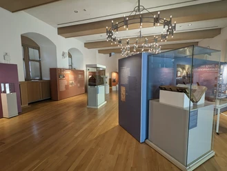 17.9._SoA 1123 ©Kreismuseum Wewelsburg.jpg Ausstellungsraum mit Holzboden im Kreismuseum Wewelsburg zeigt historische Exponate und Schautafeln.