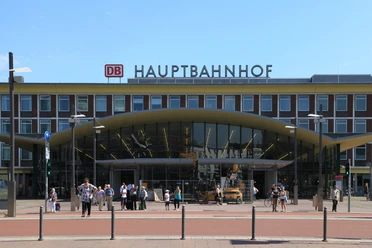 Die Eingangshalle des Hauptbahnhof Bochum ist ein großes Gebäude mit einer Uhr und der Aufschrift Hauptbahnhof auf dem Dach.