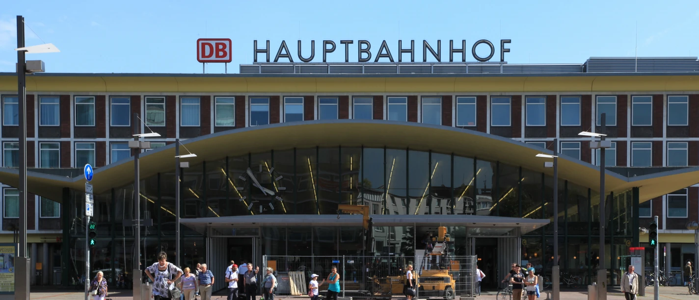 Die Eingangshalle des Hauptbahnhof Bochum ist ein großes Gebäude mit einer Uhr und der Aufschrift Hauptbahnhof auf dem Dach.