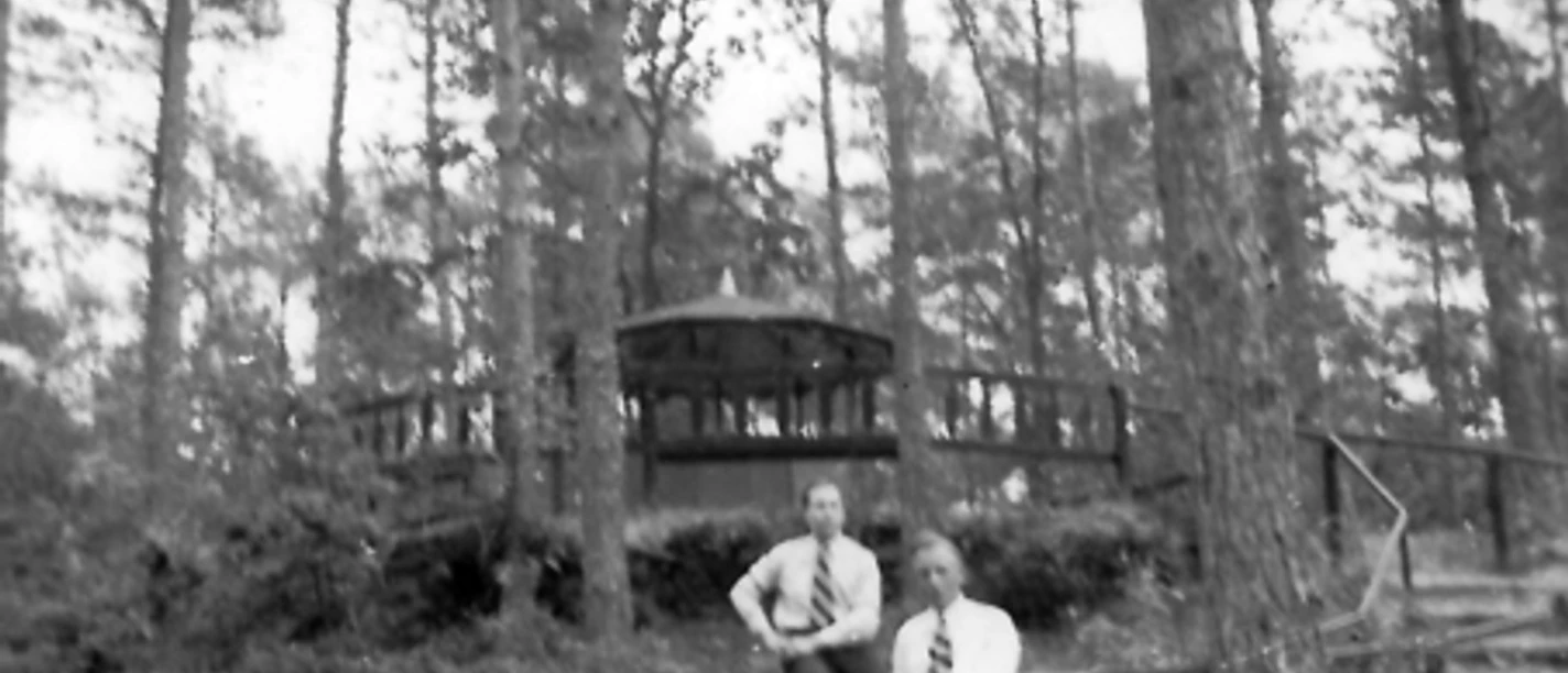 Johannesplatte im Bürgerpark Zwei Männer in Anzug und Krawatte vor einer hölzernen Aussichtsplattform im bewaldeten Bürgerpark.