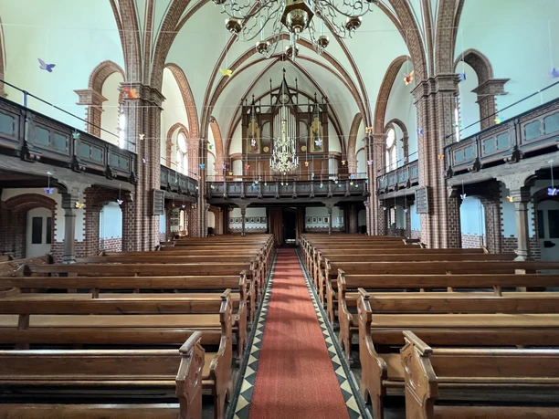 Ein beeindruckender Innenraum der St. Jakobi-Kirche in Wittlohe mit Kirchenschiff und Orgel.