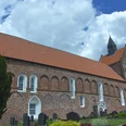 Evangelisch-reformierte Kirche Eilsum Backsteinkirche mit hohem Satteldach und Turm, umgeben vom Friedhof.
