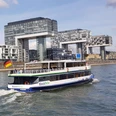 Kölntourist Personenschiffahrt Ein Ausflugsschiff namens 'RheinPerle' fährt vor der modernen Architektur der Kranhäuser in Köln.An excursion boat called 'RheinPerle' sails in front of the modern architecture of the crane buildings in Cologne.