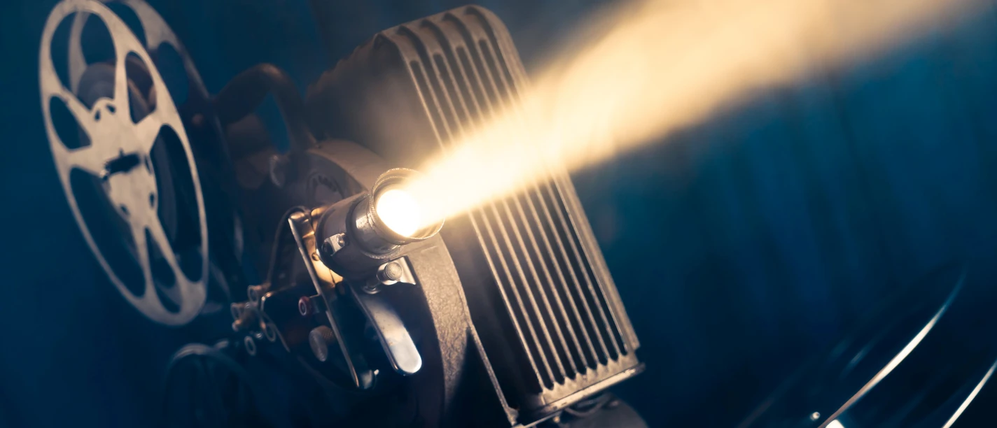 Schmalfilm- Museum Alter Filmprojektor strahlt Licht durch den Raum und setzt Filmrollen in Bewegung.