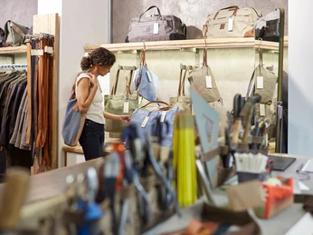 Belgian Quarter Das Bild zeigt eine Person, die in einem Lederwarengeschäft in Köln einkauft und Taschen betrachtet.The image shows a person shopping in a leather goods store in Cologne and looking at bags.