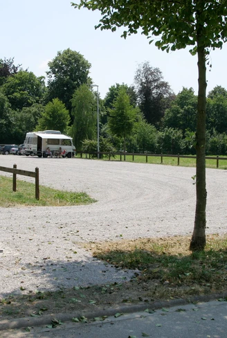 Wohnmobilstellplatz mit Schotterweg und Bäumen. Wasserversorgungseinrichtung und Schmutzwasser-Entsorgungsanlage