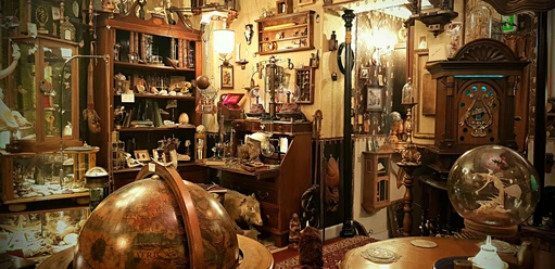 Panorama - Wunderkammer.jpg Ein dicht gefüllter Raum mit antiken und kuriosen Sammlungsstücken; ein Globus im Vordergrund.