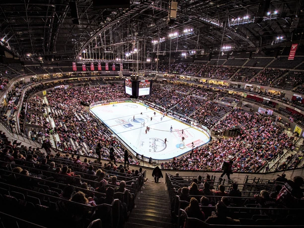 Lanxess Arena Die Lanxess Arena in Köln zeigt ein spannendes Eishockeyspiel mit einem vollen Publikum in den Rängen.