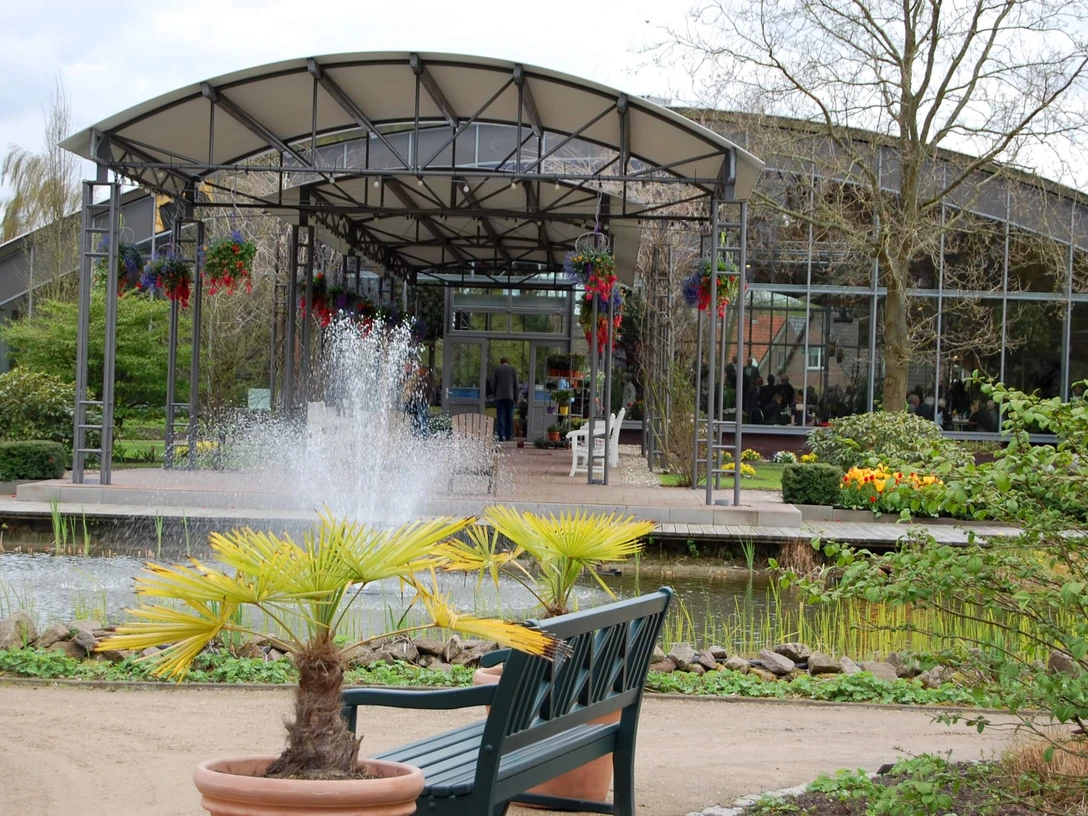Blumenreich mit Blumenhalle Wiesmoor Gartenpark mit Sicht zum Gang der in die Blumenhalle führtGarden park with view of the corridor leading to the flower hallHavepark med udsigt til korridoren, der fører til blomsterhallenTuinpark met zicht op de gang die naar de bloemenhal leidt