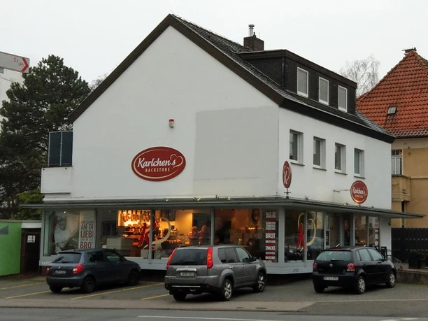 Filiale von Karlchen’s Backstube mit hellen Schaufenstern und parkenden Autos