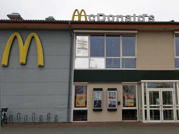 Fassade eines McDonald’s-Restaurants mit goldenem M, Fenstern und Glaseingang