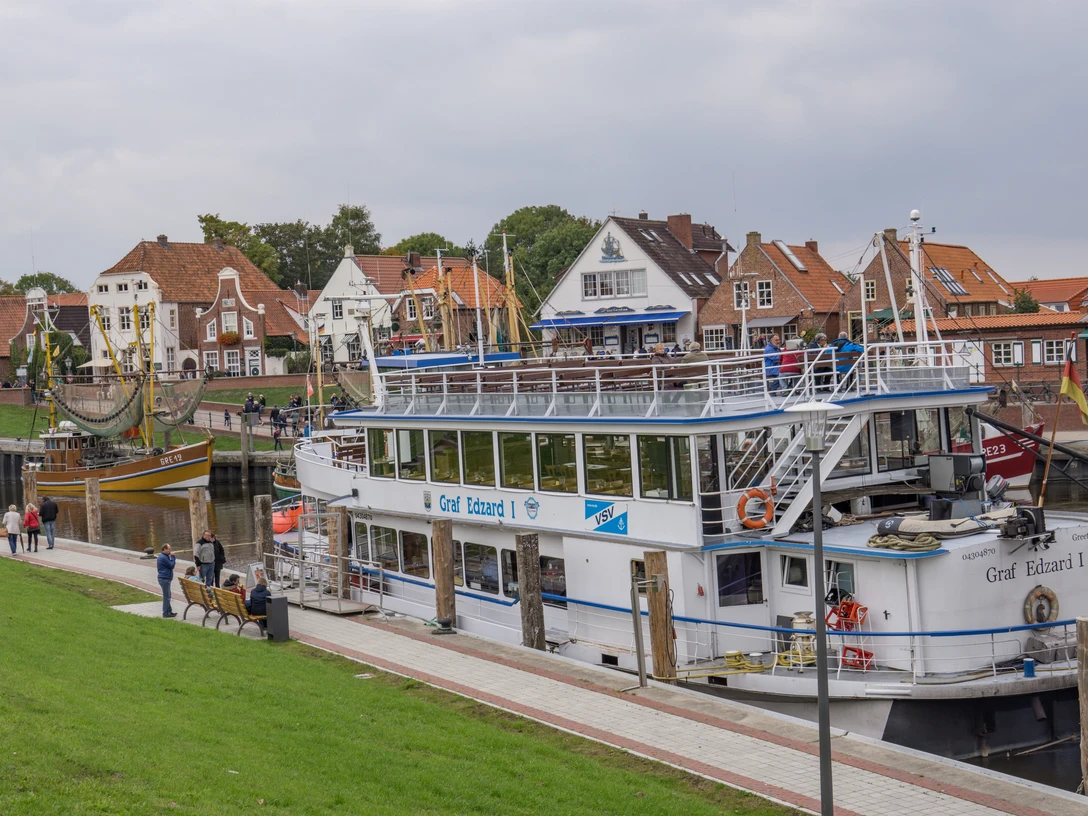 Fahrgastschiff Graf Edzard I Fahrgastschiff Graf Edzard I liegt am Kai von Greetsiel vor historischen Backsteinhäusern.