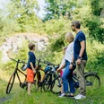 Steinbruch Langes Tal_besimmazhiqi-35.jpg Familie mit zwei Kindern steht mit Fahrrädern in einem grünen Tal nahe eines alten Steinbruchs.