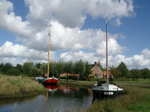 bilder_wiesmoor-010 zwei alte Schiffe auf einem Kanal, im Hintergrund ein Haus