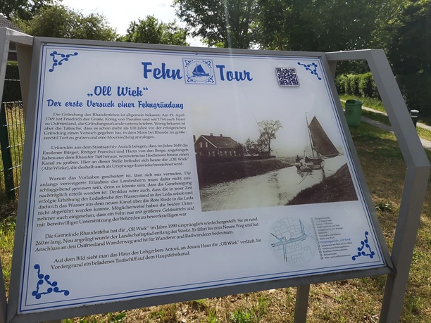 Fehntour, Rhauderfehn, Ostfriesland Informationstafel zur Fehn-Tour Oll Wieck mit historischem Text und altem Foto eines Hafens und Segelbootes