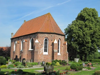 Kapelle_Vreschen-Bokel Die Kapelle in Vreschen-Bokel aus Backstein mit roten Dachziegeln, umgeben von gepflegten Gräbern und Pflanzen.