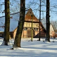 freilichtmuseum-schnee Historische Fachwerkhäuser des Freilichtmuseums Bad Zwischenahn im Schnee, umgeben von Bäumen bei Wintersonne.