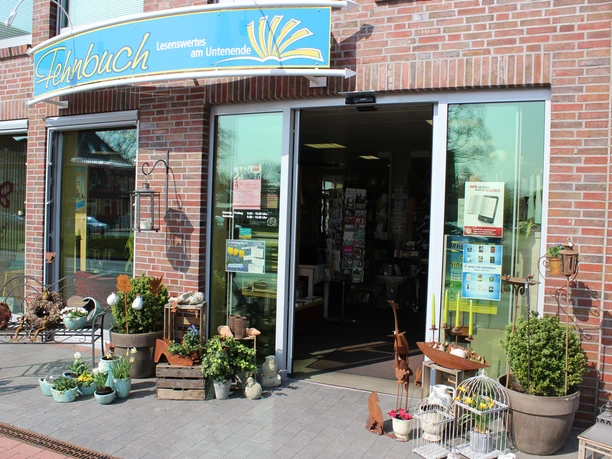 Fehnbuch, Rhauderfehn Außenansicht von der Fehnbuchhandlung mit Sicht auf die Eingangstür und Dekosachen davor.