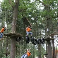 People climb on exciting rope constructions in a forest and enjoy an adventure.