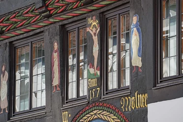 Farbiges Schnitzwerk mit Darstellung der Schöpfungsgeschichte an Fachwerkhaus