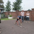 Donnerstag-Gruppe Eine Gruppe von Menschen spielt Boule auf einem Kiesplatz vor einer alten Backsteinmauer.