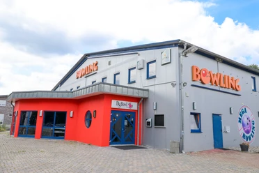 DS Bowl in Lingen Modernes Bowlingcenter mit grauer Fassade, rotem Eingangsbereich und blauen Türen in Lingen.