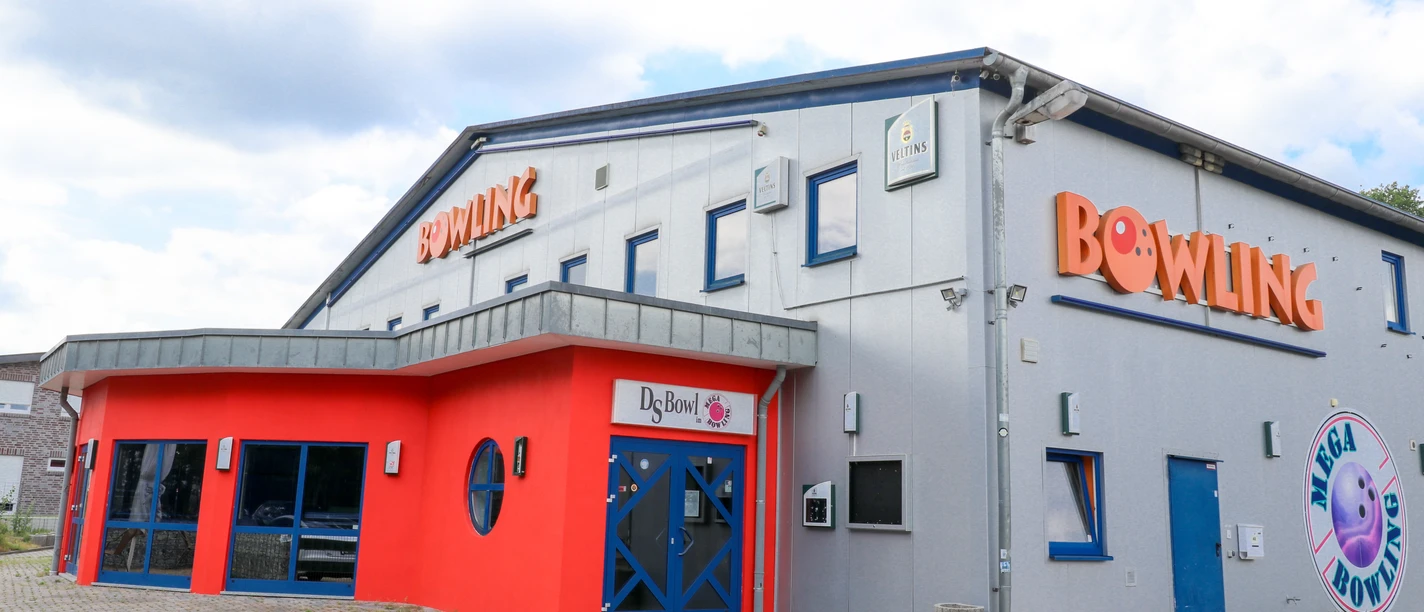 DS Bowl in Lingen Modernes Bowlingcenter mit grauer Fassade, rotem Eingangsbereich und blauen Türen in Lingen.