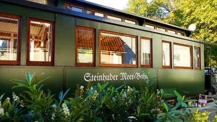 Ein dunkelgrüner Waggon mit großen Fenstern zeigt den Schriftzug „Steinhuder Meer Bahn“.