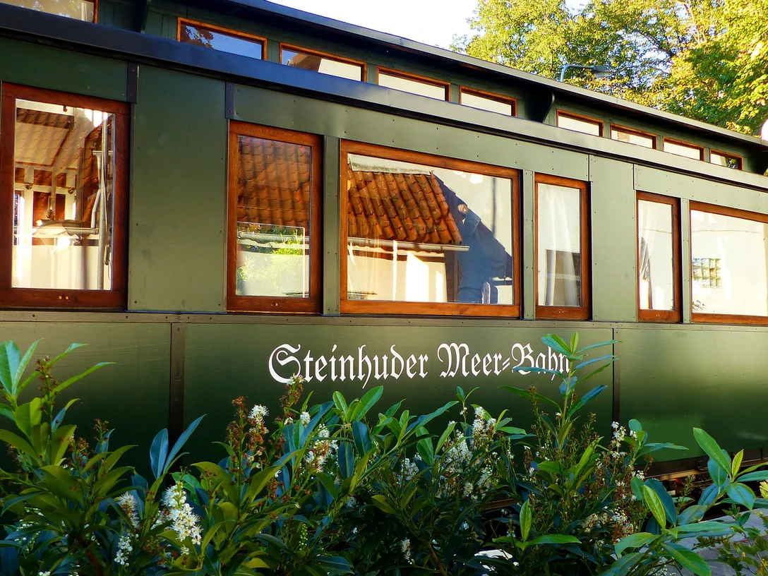Ein dunkelgrüner Waggon mit großen Fenstern zeigt den Schriftzug „Steinhuder Meer Bahn“.