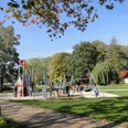 Spielplatz im Park Ein weitläufiger Spielplatz mit modernen Kletteranlagen, umgeben von Bäumen im Park.