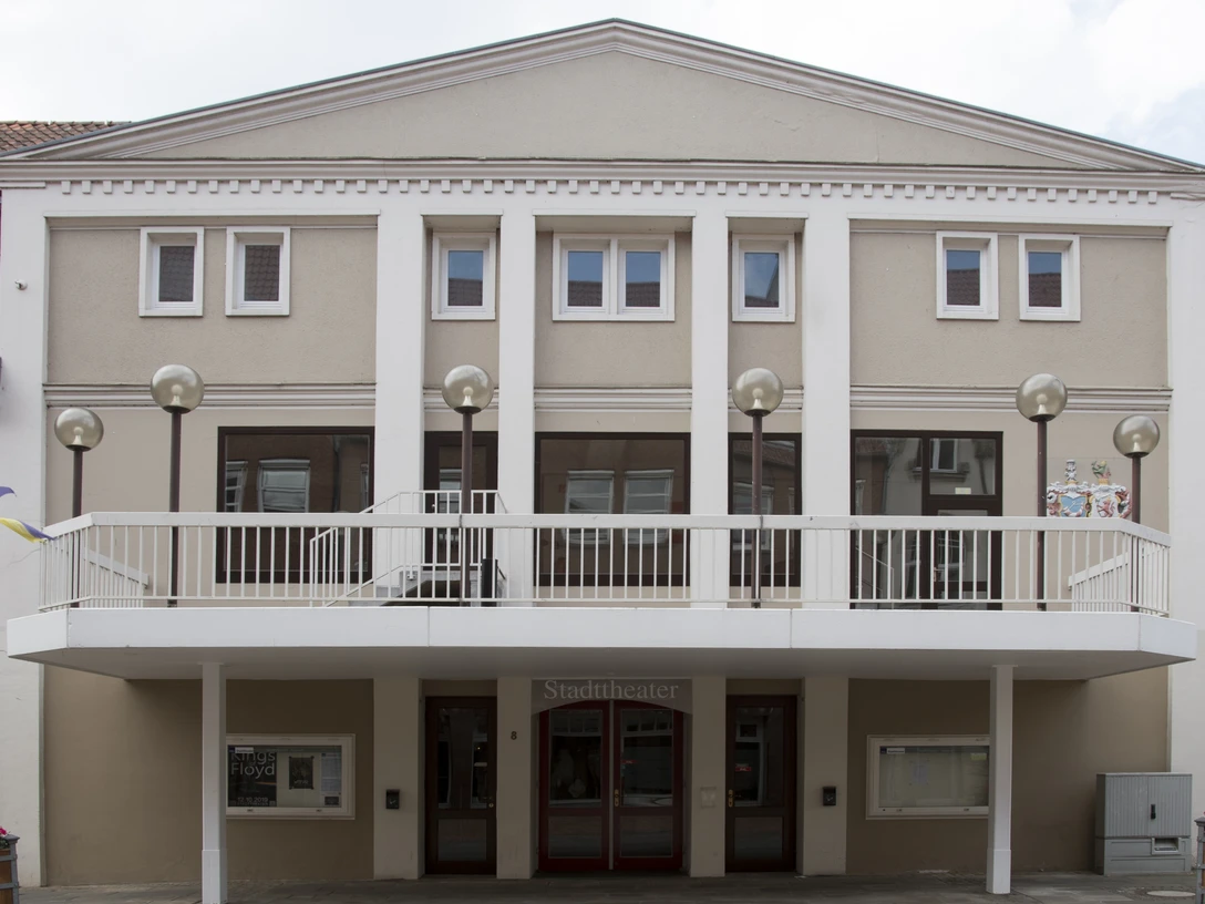 Das Stadttheater Wunstorf zeigt eine schlichte Fassade mit mehreren Fenstern und einem überdachten Eingang.