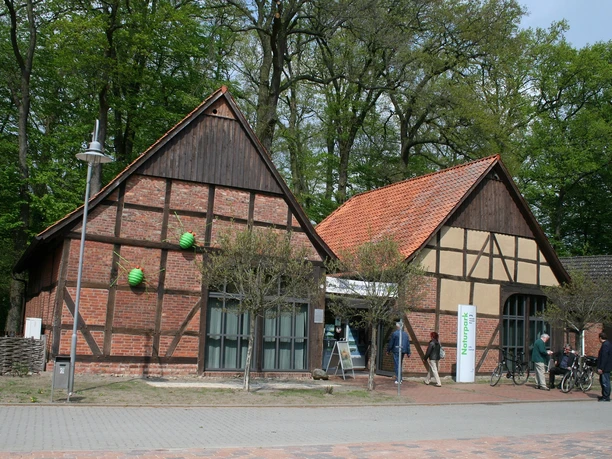 Historisches Fachwerkgebäude aus roten Ziegeln mit begrüntem Umfeld am Naturpark Steinhuder Meer.