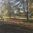 Spielplatz Försterwiese Spielplatz in herbstlicher Landschaft mit Schaukeln und Rutsche, umgeben von Bäumen und Grünfläche.