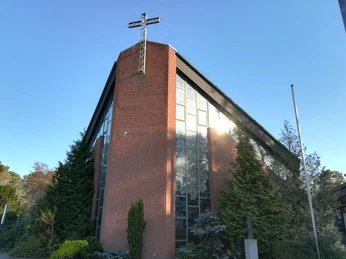 St. Hedwig Kirche Steinhude von außen Backsteinfassade der St. Hedwig Kirche in Steinhude, umgeben von grünen Bäumen und klarem Himmel.