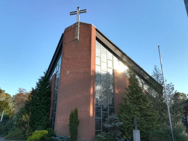 St. Hedwig Kirche Steinhude von außen Backsteinfassade der St. Hedwig Kirche in Steinhude, umgeben von grünen Bäumen und klarem Himmel.